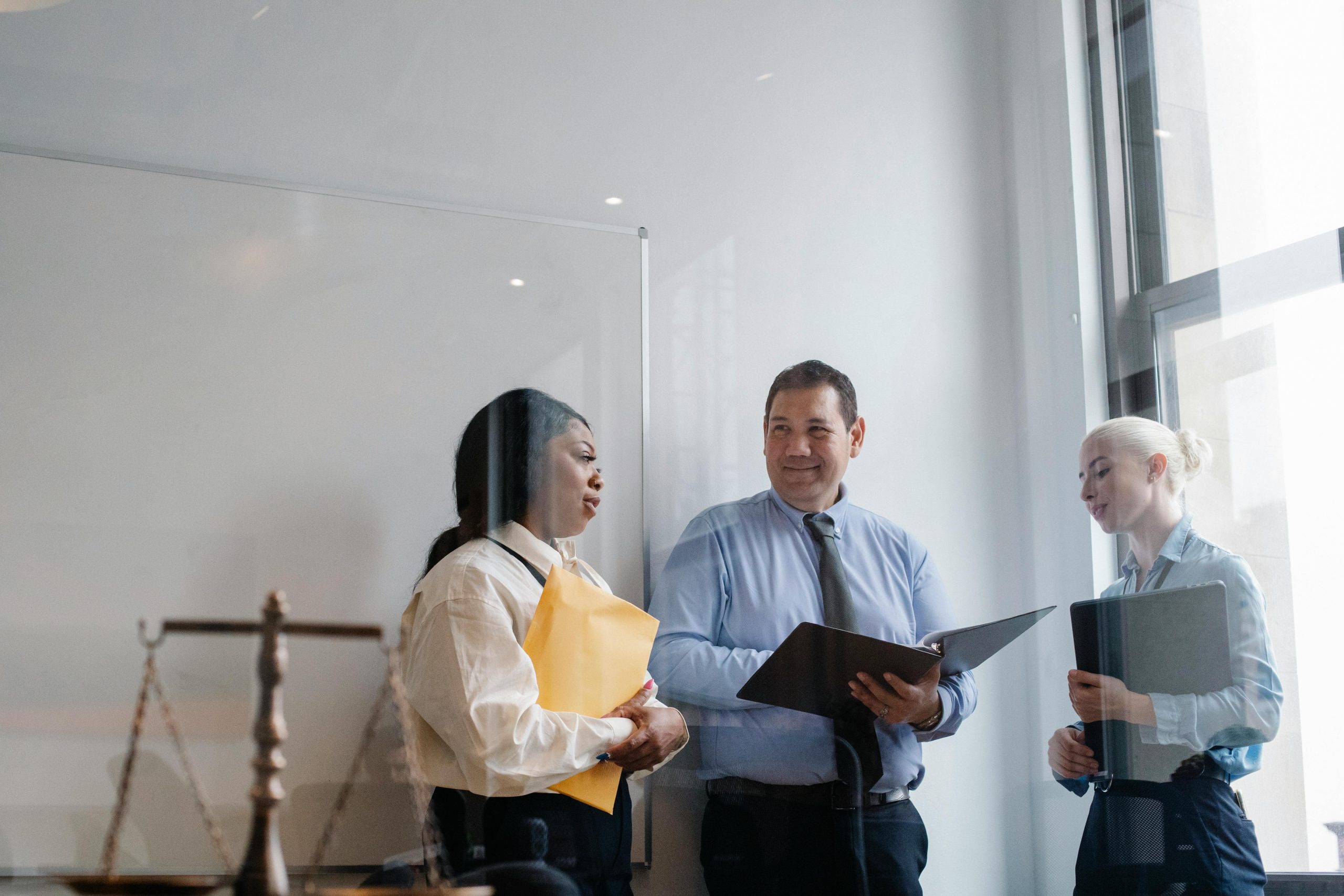 A diverse group of legal professionals discuss in a modern office setting, emphasizing collaboration and teamwork.